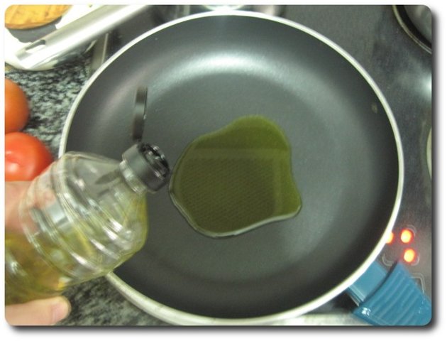 En una sartén amplia, esta es de 28 cm., echamos unas 4 cucharadas de aceite de oliva virgen extra. Lo ponemos a fuego medio.