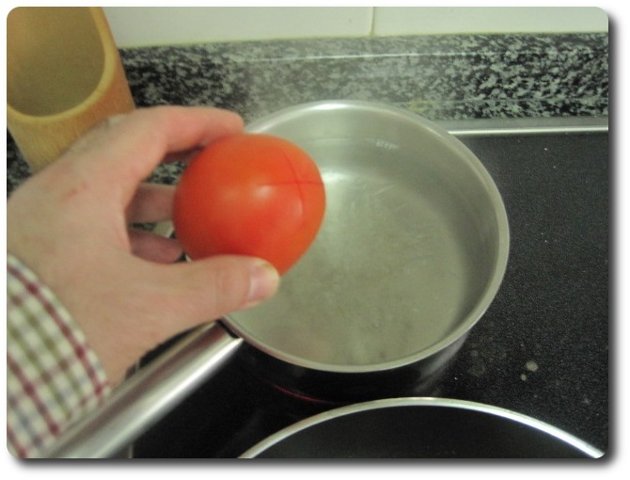 Cuando el agua hierva, echamos dentro los tomates. Los tendemos ahí 1 minuto, aproximadamente.