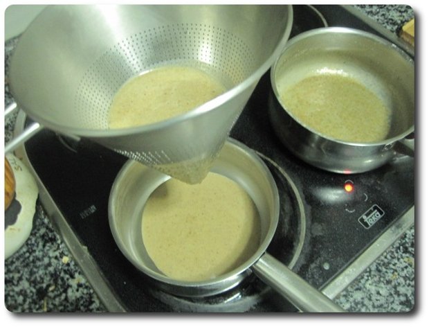 Aquí tenemos varias alternativas. Podemos mezclarlo ya con el chocolate, y nos quedarán bastantes restos de avellana no disuelta. A mí me gusta más la opción de pasar esta mezcla por un chino, eliminando gran parte de la avellana , pero no toda, pues volveremos la mezcla colada a este cazo, donde queda algo de avellana sin disolver.