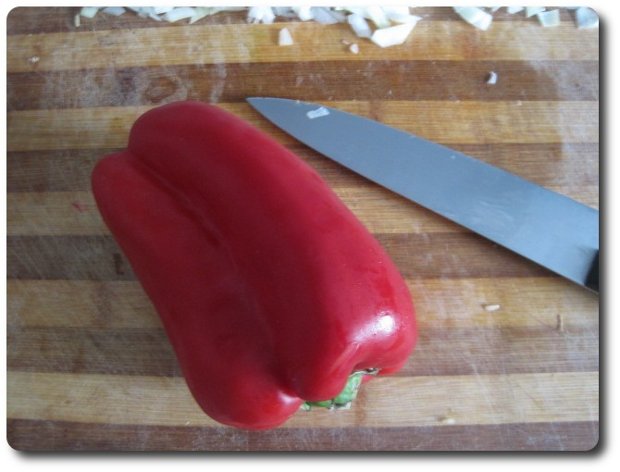 Vamos a cortar un pimiento. Puede usarse tanto verde como rojo, pero a mí me gusta más usar el rojo en esta receta pues, y aunque echaremos pimentón luego, contribuye a darle un mejor color rojizo al plato.