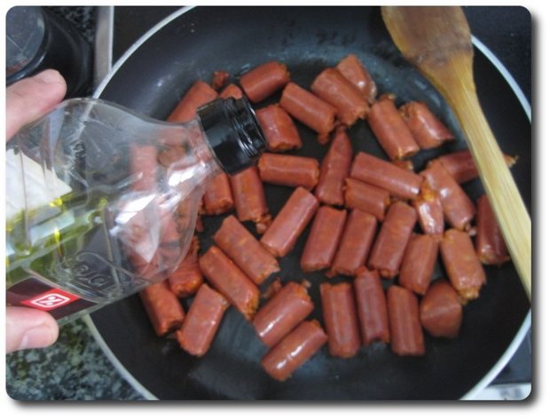 Les echamos un chorrito de nada de aceite por encima. Más que nada para arrancar, pues queremos que la txistorra suelte su grasa, y se acabará haciendo en esa misma grasa.