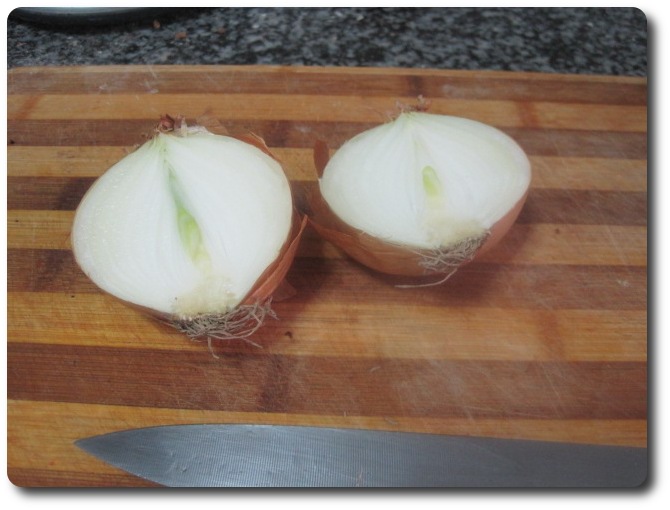 La cortamos por la mitad, de norte a sur. Tan solo vamos a usar media cebolla de tamaño medio. Esto es como la tortilla. Hay a quien le gusta con mucha….con poca….o incluso con ninguna. Media cebolla me parece que está bien. Pero bueno, a gusto de cada cual.