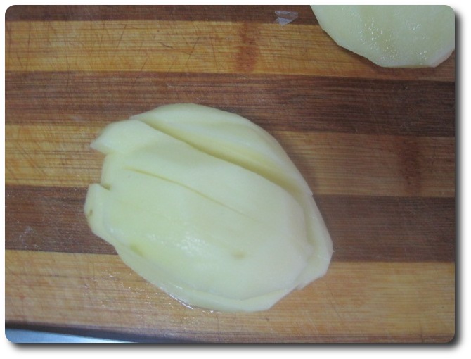 Tumbando la patata por su parte plana, le damos otros cortes paralelos a lo largo.