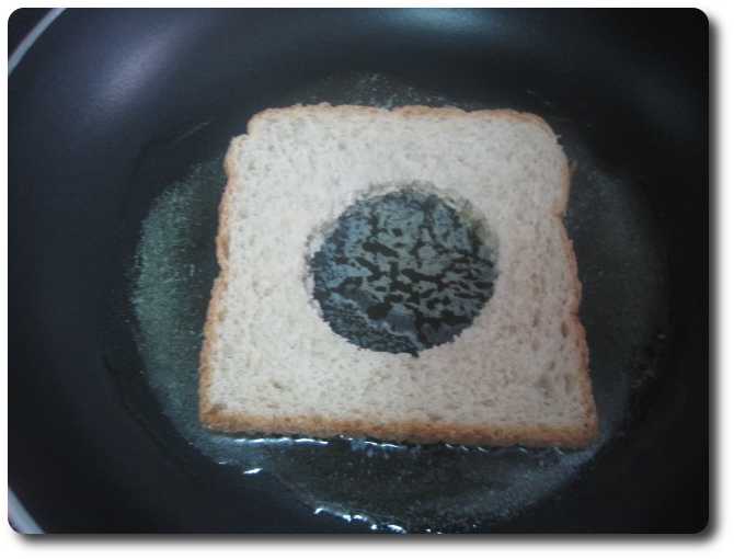 Colocamos la rebanada de pan en el centro, procurando que tenga bastante mantequilla derretida debajo.