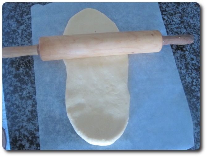 Lo vamos a extender con el rodillo. Si vemos que se nos pega la masa al rodillo, es buena idea colocar la masa entre dos tiras de papel.